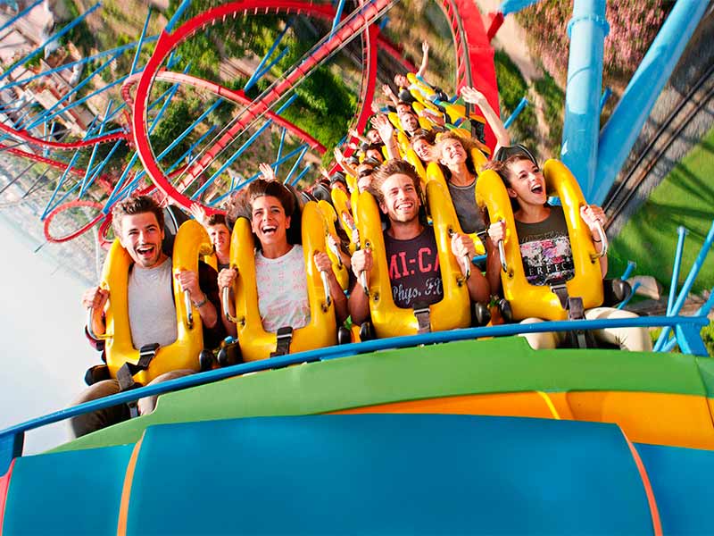 Visitantes a desfrutar de uma montanha-russa em PortAventura Park