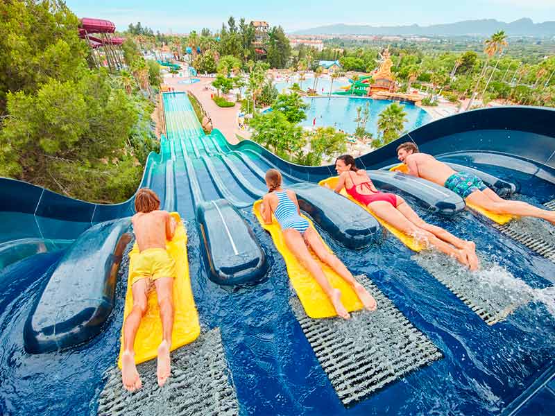 Visitantes a descer os escorregas de Caribe Aquatic Park em tapetes aquáticos